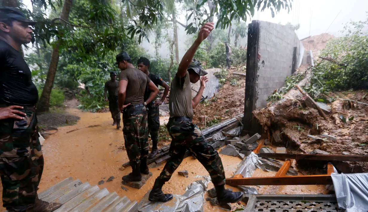 Petugas Militer Sri Lanka membantu membersihkan puing rumah warga usai longsor di Desa Elangipitiya, Aranayaka, Sri Lanka (19/5). Ratusan warga dikabarkan hilang akibat tanah longsor tersebut. (REUTERS/Dinuka Liyanawatte)