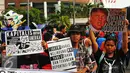 Sejumlah masa yang tergabung dalam front Perjuangan Rakyat membawa poster saat melakukan aksi yang mengecam kebijakan Presiden Amerika Serikat Donald Trump di Jakarta, Minggu (5/2). (Liputan6.com/Angga Yuniar)