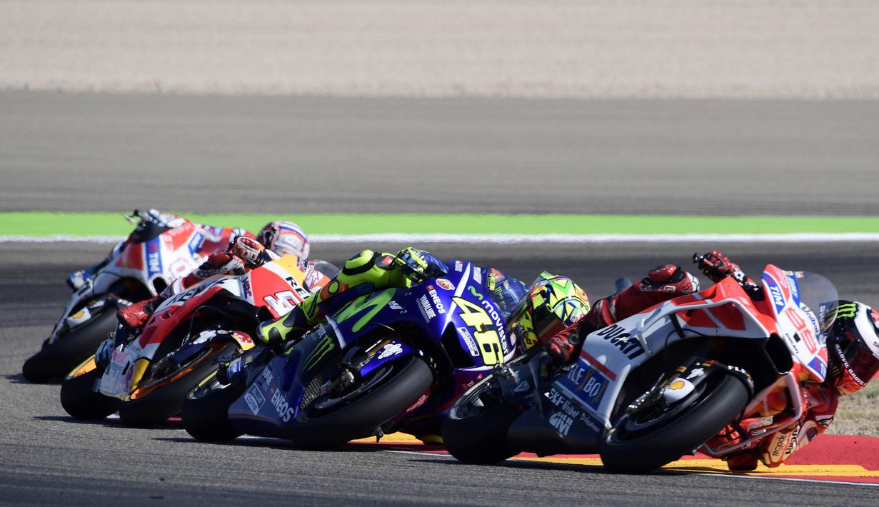 Pebalap Movistar Yamaha, Valentino Rossi, berusaha membalap pebalap Ducati, Jorge Lorenzo pada GP Aragon di Sirkuit Motorland, Alcaniz, Minggu (24/9/2017). Lorenzo finis ketiga dengan waktu 42 menit 8,844 detik. (AFP/Javier Soriano)