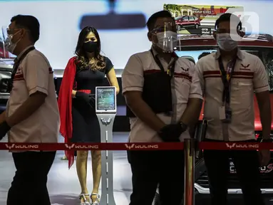 Sales Promotion Girl berdiri dekat mobil yang dipamerkan di Indonesia International Motor Show (IIMS) Hybrid 2021, JiExpo Kemayoran, Jakarta, Kamis (16/4/2021). Pameran otomotif IIMS Hybrid 2021 berlangsung pada 15-25 April. (Liputan6.com/Johan Tallo)
