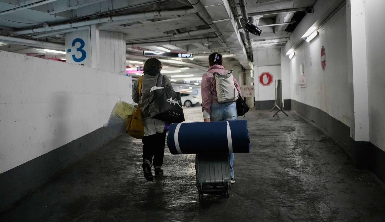 Sebelumnya diketahui, sejumlah warga Israel menghabiskan hari-hari di tempat parkir bawah tanah yang disulap menjadi tempat perlindungan, bahkan menggunakannya untuk beraktivitas. Tampak dalam foto, orang-orang membawa barang-barang mereka saat meninggalkan tempat perlindungan bawah tanah tempat mereka tinggal selama perang dengan Iran, setelah pengumuman gencatan senjata selama dua minggu, di Tel Aviv, Israel, Rabu 8 April 2026. (AP Photo/Ohad Zwigenberg)