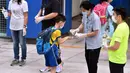 Seorang murid mendisinfeksi tangannya sebelum memasuki sekolah di Tsuen Wan, Hong Kong, China selatan, pada 29 September 2020. Aturan menjaga jarak sosial (social distancing) sebagian telah dilonggarkan dan kehidupan masyarakat mulai kembali normal. (Xinhua/Lo Ping Fai)