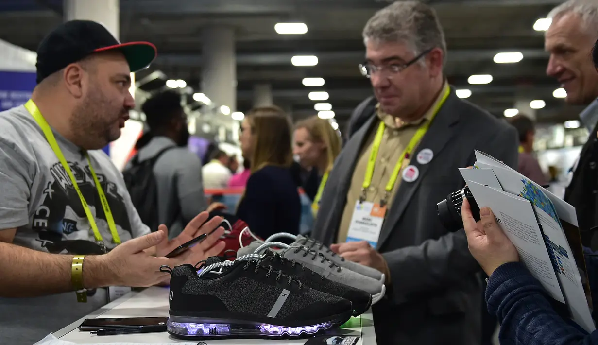 Pengunjung melihat sepatu lampu Wize & Ope di Consumer Electronic Show (CES), Las Vegas (5/1). sepatu ini dapat menyala dengan bantuan smartphone. (AFP Photo/Frederic J. Brown)