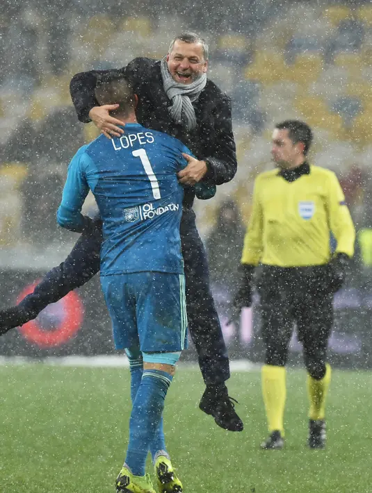 Kiper Olympique Lyon, Anthony Lopes memeluk pelatih Bruno Genesio usai laga melawan Shakhtar Donetsk pada penyisihan Grup F Liga Champions di Stadion NSK Olimpiyskyi, Kiev, Rabu (12/12). Lyon lolos ke 16 besar Liga Champions. (GENYA SAVILOV/AFP)