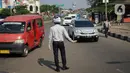 Petugas Dishub mengatur lalu lintas saat melakukan sosialisasi penggunaan masker kepada pengendara sepeda motor di kawasan Depok, Jawa Barat, Senin (20/7/2020). Setelah sosialisasi, Pemkot Depok akan menerapkan sanksi denda kepada warga yang melanggar. (Liputan6.com/Immanuel Antonius)