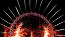 Kembang api menghiasi London Eye saat perayaan malam Tahun Baru 2019 di London, Inggris, Selasa (1/1). (AP Photo/Kirsty Wigglesworth)