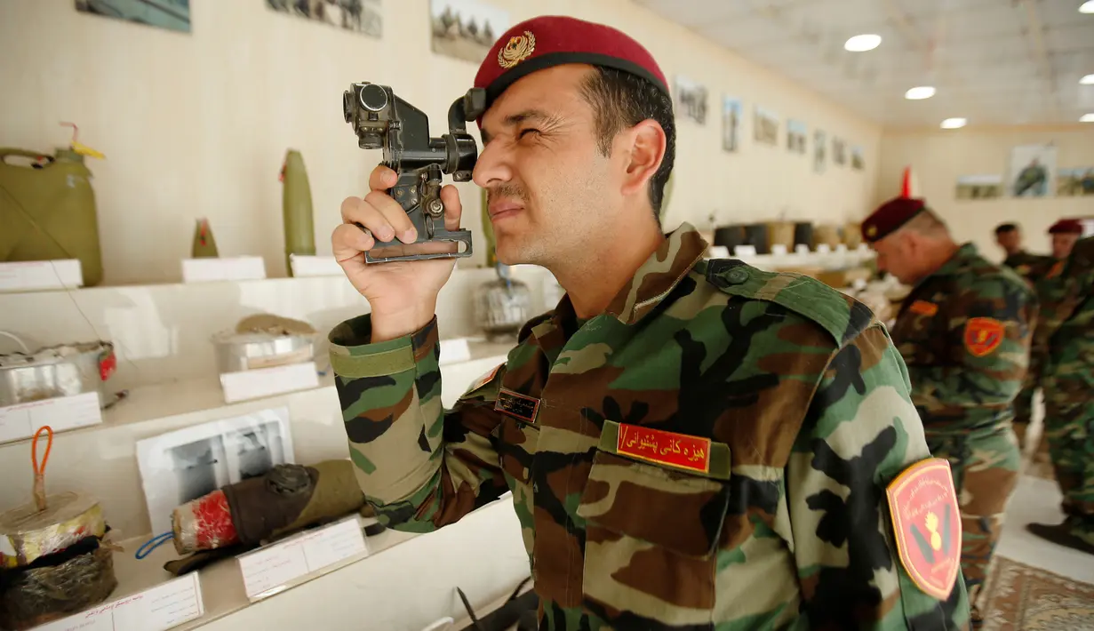 Militer Kurdi Peshmerga melihat melalui alat yang digunakan oleh militan negara Islam (ISIS)  di sebuah museum di Erbil, Irak, 12 Mei 2019. Museum itu memamerkan memorabilia perang dan benda-benda yang berhasil direbut dalam pertempuran dengan ISIS. (REUTERS/Azad Lashkari)