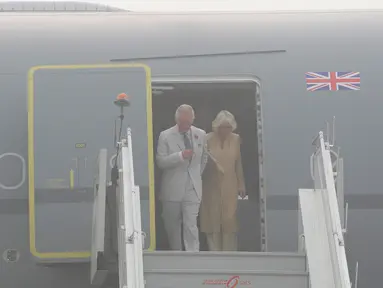 Pangeran Charles dan istrinya, Camilla bersiap turun dari sebuah pesawat yang terselimuti kabut asap setibanya di New Delhi, India, Rabu (8/11). Pasangan dari Kerajaan Inggris itu akan berada di negara Anak Benua selama dua hari. (AP Photo/Manish Swarup)