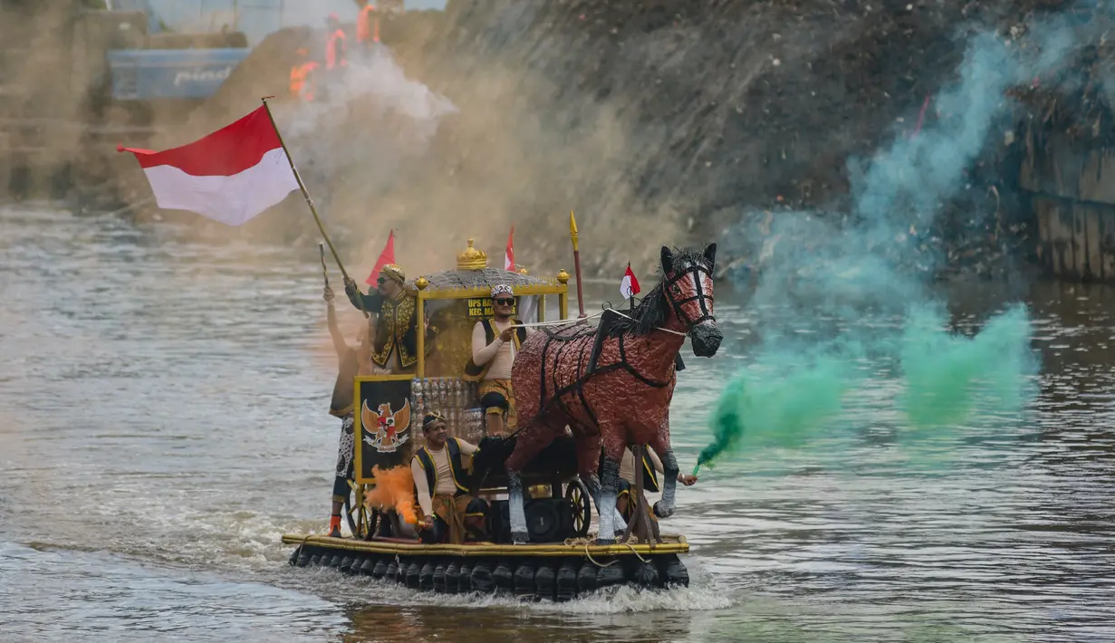 Peserta berparade dengan perahu yang terbuat dari sampah daur ulang mengikuti Festival Perahu Cilung 2025 di kawasan jalan Inspeksi Kali Ciliwung, Pancoran, Jakarta Selatan, Minggu (28/9/2025). (merdeka.com/Arie Basuki)