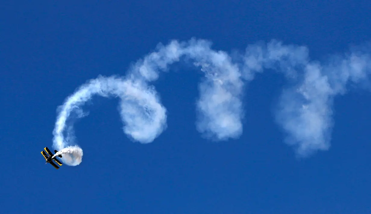 Seorang pilot melakukan gerakan spiral dengan pesawatnya saat beraksi di Brunswick, Maine (26/8). (AP Photo / Robert F. Bukaty)