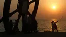 Turis mengabadikan gambar saat matahari tenggelam atau sunset di pinggir laut, Pulau Kish, Iran, 1 November 2016. Kish sudah menarik 1,8 juta pengunjung per tahun, dari 2,2 juta pada 2009 menjadi 5,2 juta pada 2015. (Atta Kenare/AFP)