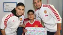 Kiper MU, Sergio Romero dan rekan setimnya, Andreas Perreira memberikan kado kepada pasien dari Rumah Sakit Royal Manchester Children. (www.manutd.com)