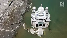 Pandangan udara Masjid Terapung Arqam Bab Al Rahman pasca gempa dan tsunami Palu di Pantai Talise, Sulawesi Tengah. Bangunan masjid yang terletak di pinggir pantai terlihat utuh meski sebagian bangunannya tenggelam. (Liputan6.com/Fery Padolo)