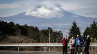 Orang-orang sedang berfoto di depan Gunung Fuji Jepang di kota Gotemba, prefektur Shizuoka. (Dok: Yuichi YAMAZAKI / AFP)