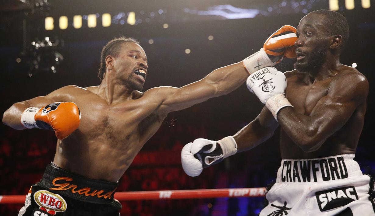 Shawn Porter (kiri) memukul Terence Crawford pada pertandingan tinju perebutan gelar juara dunia kelas welter WBO di Las Vegas, Amerika Serikat, 20 November 2021. Terence Crawford menang TKO pada ronde 10. (AP Photo/Chase Stevens)
