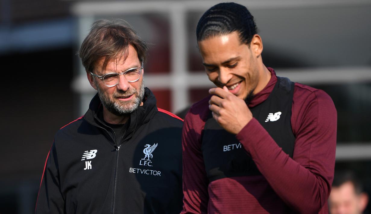 Pelatih Liverpool, Jurgen Klopp, berbincang dengan Virgil van Dijk saat sesi latihan jelang laga Liga Champions di Melwood, Liverpool, Senin (8/4). Liverpool akan berhadapna dengan Porto. (AFP/Paul Ellis)