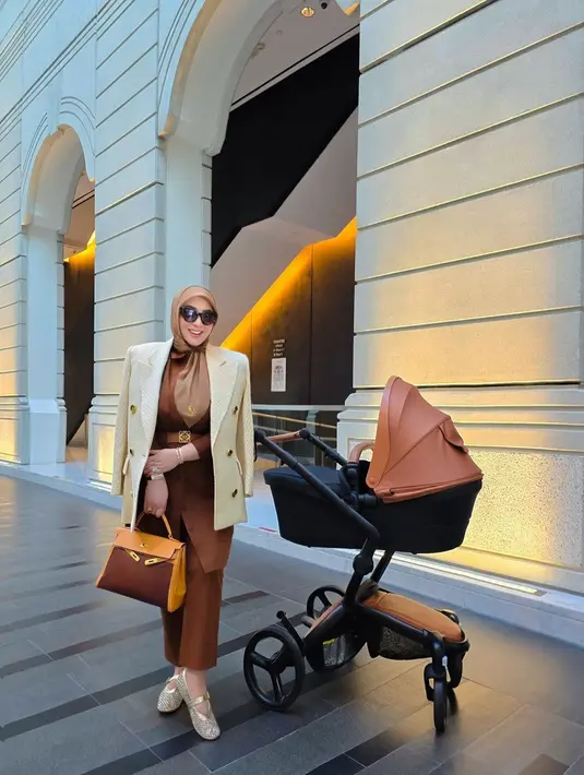 Penampilannya dilengkapi dengan tas Hermes k32 retourne 2way ebene & gold calf leather with gold hardware - 1999 pre-owned. Menurut situs Farfetch, harganya mencapai Rp183 jutaan. [@princessyahrini].