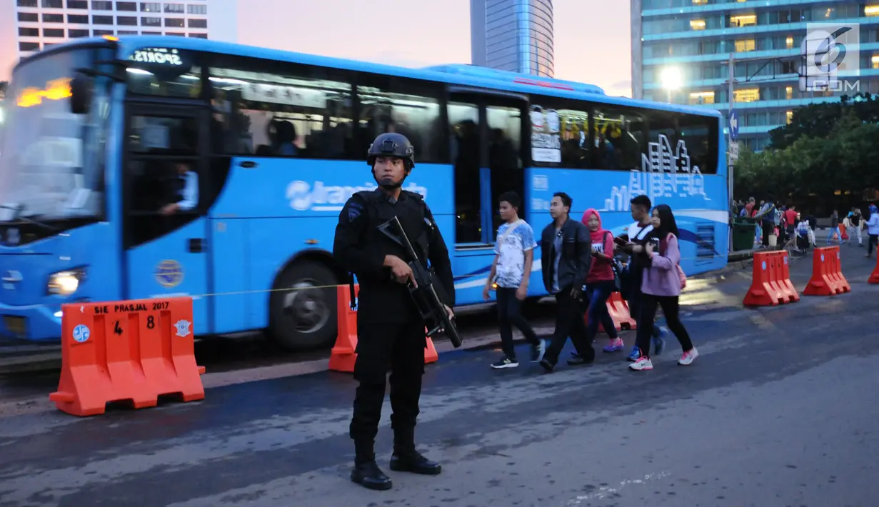Personel Brimob berjaga di kawasan Bundaran Hotel Indonesia jelang malam pergantian tahun, Minggu (31/12). 20.000 tim gabungan dari TNI dan Polri dikerahkan untuk mengamankan malam tahun baru 2018 di Jakarta. (Liputan6.com/Helmi Fithriansyah)