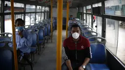 Penumpang mengenakan masker di sebuah bus di Kathmandu (16/7/2020). Beberapa perusahaan angkutan umum di Lembah Kathmandu sudah mulai mengoperasikan kembali rute mereka untuk pertama kalinya dalam hampir empat bulan setelah menerima persyaratan operasional dari pemerintah. (Xinhua/Sulav Shrestha)