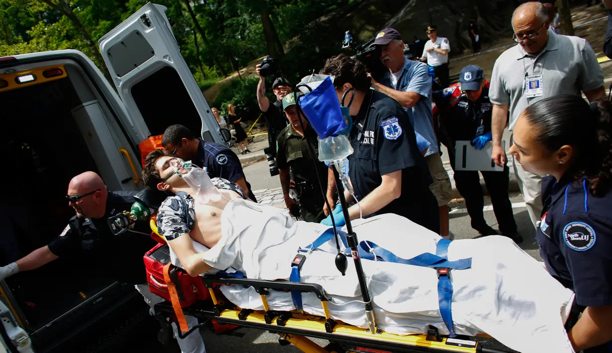 Seorang pemuda korban ledakan di Central Park, New York, dimasukkan ke dalam ambulans, Minggu (3/7). Belum diketahui penyebab ledakan itu, tapi ada dugaan ledakan disebabkan oleh kembang api menjelang Hari Kemerdekaan pada Senin (4/7). (Kena Betancur/AFP)