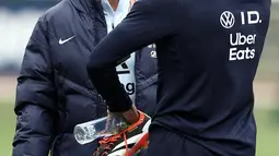 Pelatih kepala Prancis, Didier Deschamps (kiri) berbincang bersamaJules Kounde dalam sesi latihan untuk pertandingan sepak bola persahabatan melawan Jerman dan Chili, di Clairefontaine-en-Yvelines, 18 Maret 2024. (FRANCK FIFE/AFP)