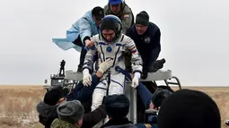 Petugas membantu Kosmonot Rusia, Sergei Volkov untuk keluar dari pesawat kapsul Soyuz yang mendarat di kota Dzhezkazgan, Kazakhstan , (2/3). Para Kosmonot kembali ke Bumi setelah 1 tahun berada di luar angkasa. (REUTERS / Kirill Kudryavtsev)