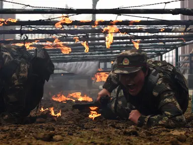 Tentara wanita China melewati rintangan api saat melakukan latihan militer jelang Hari Perempuan Internasional di Hefei, China (6/4). (AFP)