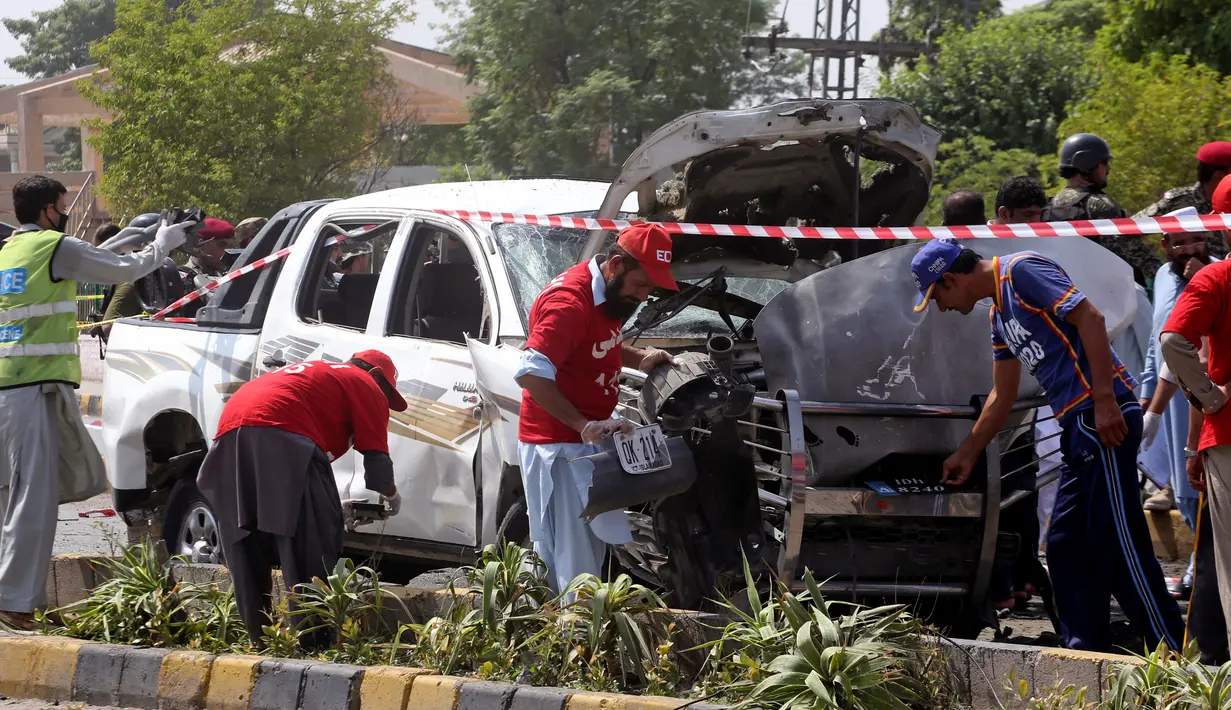Pakistan, Senin, (17/7).Menurut polisi setempat Bom bunuh diri tersebut menewaskan dua orang dan melukai enam lainnya. (AP Photo / Muhammad Sajjad) Petugas keamanan Pakistan dan relawan mengumpulkan bukti di lokasi pemboman di Peshawar, 