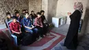 Anak-anak Palestina menghadiri kelas di sekolah bersejarah "Al-Kamaliya al-Othmanya" di Kota Tua Gaza yang menjadi bagian dari inisiatif sukarelawan yang diorganisir oleh para guru pengungsi, di Kota Gaza pada 2 November 2025. Diketahui, ada lebih dari 650 ribu anak kehilangan akses pendidikan formal sejak perang antara Israel dan Hamas memanas pada Oktober 2023. (Omar AL-QATTAA/AFP)