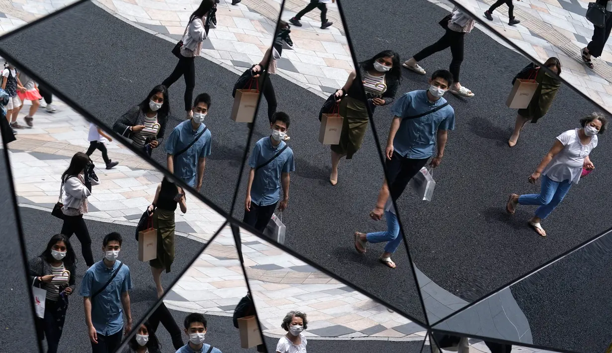 Pejalan kaki terlihat di langit-langit cermin di pusat perbelanjaan di Tokyo (11/6/2020). Cuaca panas terus berlanjut di wilayah metropolitan karena suhunya diperkirakan akan naik menjadi 31 derajat Celsius (87,8 derajat Fahrenheit), menurut biro meteorologi Jepang. (AP Photo/Eugene Hoshiko)