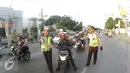 Petugas Kepolisian memberhentikan pengendara motor yang membawa balita di Simpang Maya, Tegal, Jawa Tengah Minggu (10/7). Petugas menghimbau untuk memberikan keamanan yang layak untuk anak saat berkendara. (Liputan6.com/Herman Zakharia)