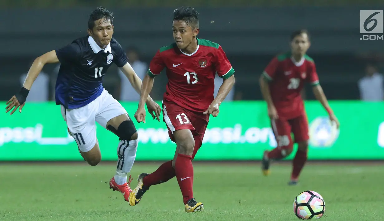Gelandang Timnas Indonesia, Febri Haryadi (tengah) menghindari kejaran pemain Kamboja, Chan Vathanaka pada laga persahabatan di Stadion Patriot Candrabhaga, Bekasi, Rabu (4/10). Timnas Indonesia menang 3-1 atas Kamboja. (Liputan6.com/Helmi Fithriansyah)