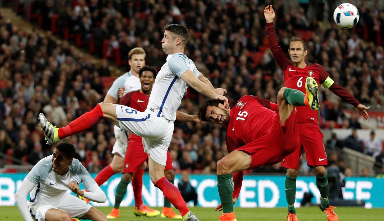 Bek Inggris, Gary Cahill, menghalau bola dari kejaran pemain Portugal, Andre Gomes, dalam laga persahabatan di Stadion Wembley, London, Kamis (2/6/2016). (AFP/Adrian Dennis)