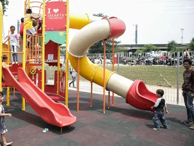 Sejumlah anak bermain di areal RPTRA Kalijodo, Jakarta, Jumat (14/4). Sejumlah warga menghabiskan libur Paskah dengan mengajak putra-putrinya bermain di areal RPTRA Kalijodo. (Liputan6.com/Faizal Fanani)