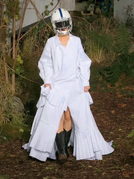 Model berjalan di atas catwalk mengenakan rancangan koleksi Fall/Winter 2019 dari brand Off-White pada Paris Fashion Week, Rabu (16/1). Dalam perhelatan itu, sejumlah model mengenakan helm futbol, saat melenggang di catwalk. (AP/Michel Euler)