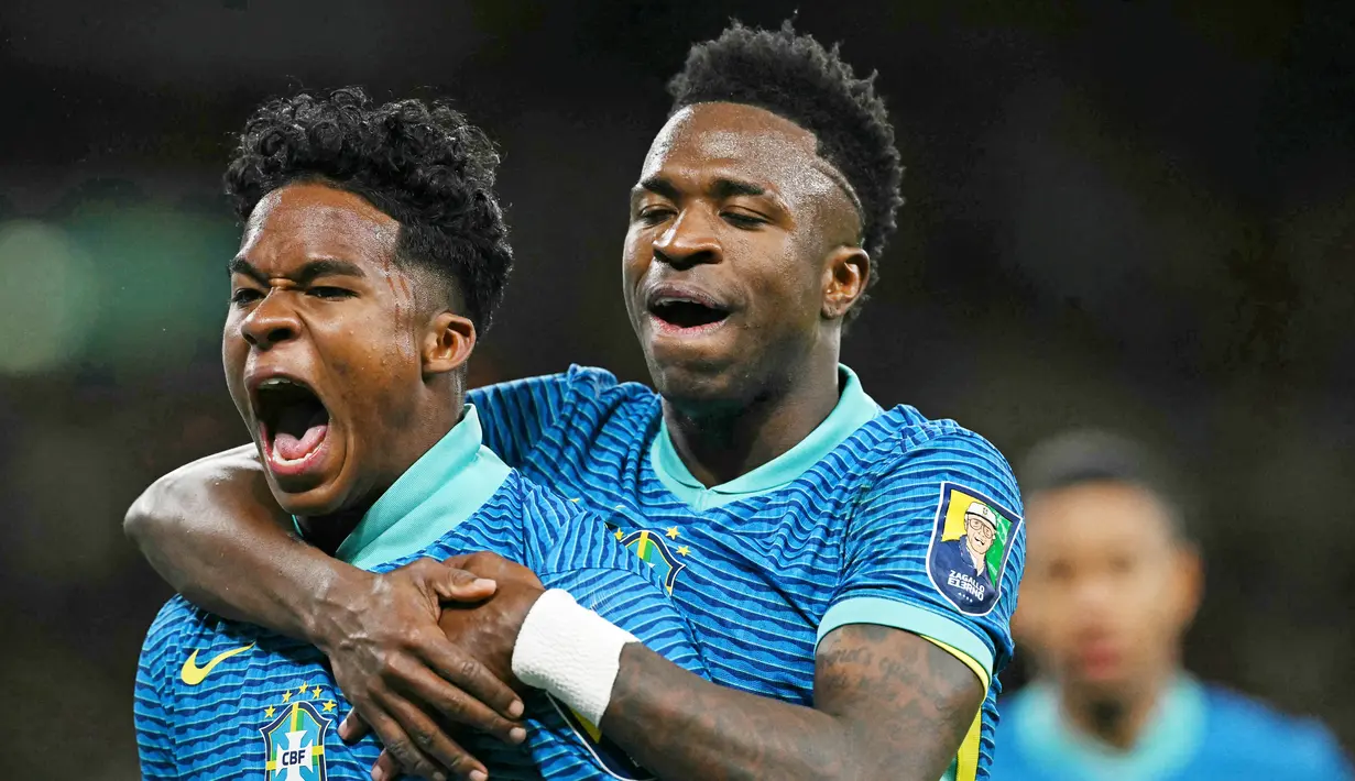 Pemain Brasil, Endrick, melakukan selebrasi bersama Vinicius Jr setelah mencetak gol ke gawang Inggris dalam laga persahabatan di Stadion Wembley, Minggu (24/3/2024). Talenta muda Brasil ini akan memperkuat Real Madrid di usia 18 nanti. (AFP/Glyn Kirk)