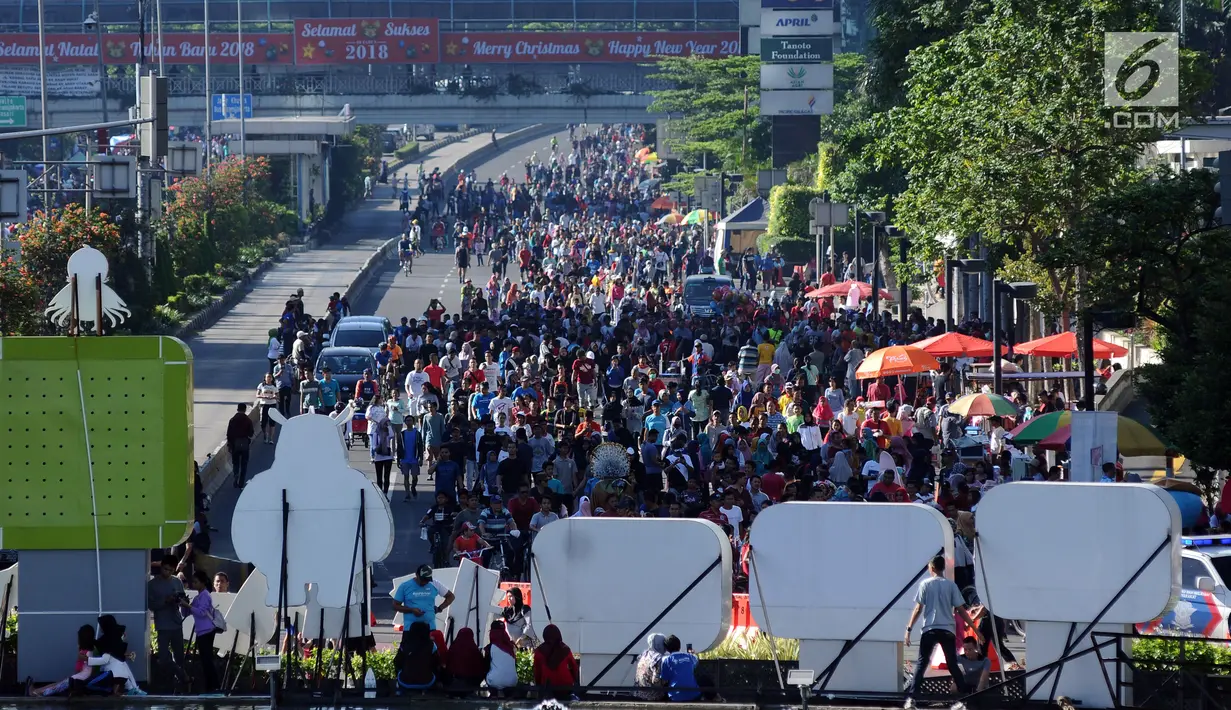 Warga berjalan di kawasan Jalan Jenderal Sudirman, Jakarta, Minggu (31/12). Meski Hari Bebas Kendaraan dipenghujung 2017 ditiadakan, warga tetap memadati kawasan sekitar Jalan Jend Sudirman dan MH Thamtin, Jakarta. (Liputan6.com/Helmi Fithriansyah)