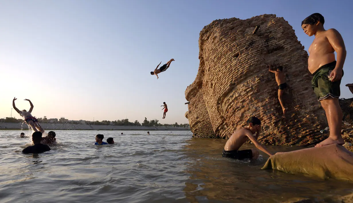 <p>Warga berenang di Sungai Tigris untuk menghalau panas, Baghdad, Irak, 13 Juli 2023. (AP Photo/Hadi Mizban)</p>