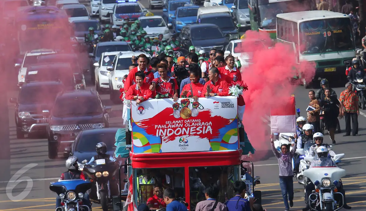 Senyum semringah para penyumbang medali Indonesia di Olimpiade Rio 2016 saat arak-arakan melintas menuju Istana Negara, Jakarta, Rabu (24/8). Arak-arakan para pahlawan olahraga itu mendapatkan perhatian dari masyarakat Jakarta. (Liputan6.com/Angga Yuniar)