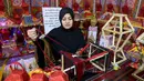 Reham Shurab, salah satu perajin Palestina menyelesaikan pembuatan lentera tradisional "fanous" untuk dekorasi menjelang bulan suci Ramadan, di bengkel rumahnya di Khan Yunis di Jalur Gaza Selatan pada Senin 13 Maret 2023. Lentera tradisional "fanous" hanya muncul saat bulan Ramadan, sehingga keberadaan lentera warna-warni itu dikenal pula dengan sebutan fanous Ramadan. (SAID KHATIB/AFP)