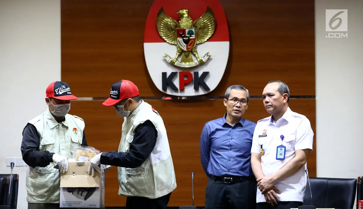 Dua petugas, Wakil Ketua KPK Alexander Marwata (kedua kanan) dan Irjen Kemenkum HAM Jhoni Ginting (kanan) jelang keterangan pers OTT di Gedung KPK, Jakarta (28/5/2019). OTT terkait penanganan perkara penyalahgunaan izin tinggal di Kantor Imigrasi Kelas I Mataram, NTB. (Liputan6.com/Johan Tallo)