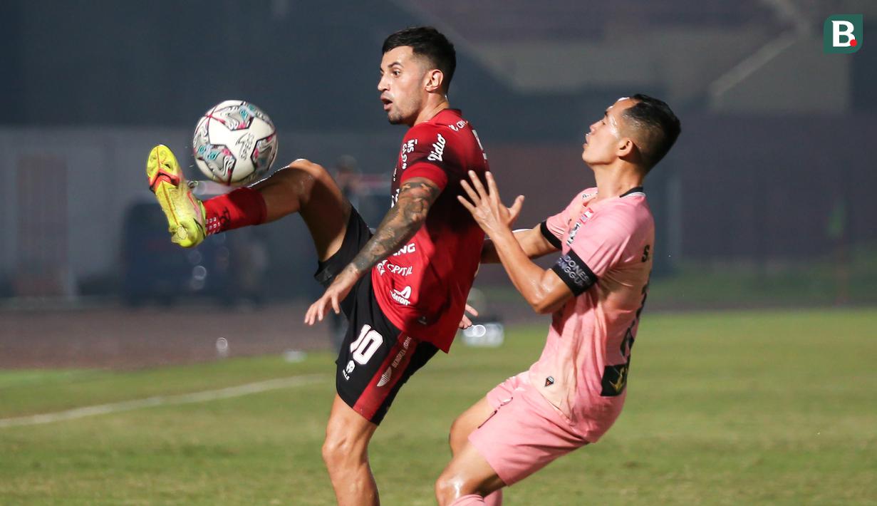 Pemain Bali United, Stefano Lilipaly (kiri) berebut bola dengan pemain Madura United, Slamet Nurcahyo dalam laga pekan ke-16 BRI Liga 1 2021/2022 di Stadion Sultan Agung, Bantul, Kamis (09/12/2021). (Bola.com/Bagaskara Lazuardi)
