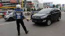 Petugas Dishub memberi arahan kepada pengendara mobil di depan Gerbang Tol Bekasi Barat 1, Bekasi, Jawa Barat, Senin (12/3). Penerapan ganjil-genap hanya berlaku di gerbang tol Bekasi Barat dan Timur. (Liputan6.com/Arya Manggala)