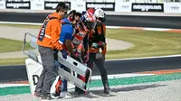 Pembalap Repsol Honda, Marc Marquez (tengah) mendapatkan bantuan tim medis setelah bersenggolan dengan pembalap Pramac Racing, Jorge Martin dalam MotoGP Valencia yang berlangsung di Sirkuit Ricardo Tormo, Valencia, Spanyol Minggu (26/11/2023). (AFP/Javier Soriano)