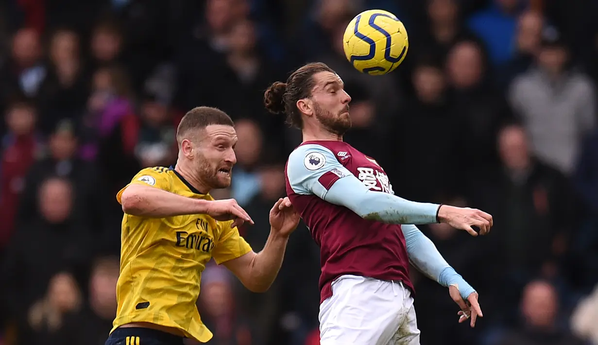 Pemain Arsenal Shkodran Mustafi (kiri) berebut bola dengan pemain Burnley Jay Rodriguez (kanan) pada pertandingan Liga Inggris di Turf Moor, Burnley, Inggris, Minggu (2/2/2020). Laga berakhir imbang tanpa gol. (Oli SCARFF/AFP)