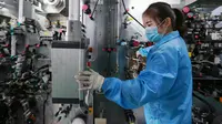 Karyawan wanita mengecek mesin saat bekerja di sebuah pabrik baterai di Huaibei di provinsi Anhui timur China (6/3). Industri listrik berkembang pesat dan saat ini berada di peringkat ketiga di China timur. (AFP Photo/STR)