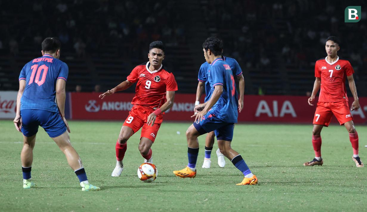 <p>Striker Timnas Indonesia U-22, Ramadhan Sananta (tengah) berusaha melewati dua pemain Thailand pada laga final cabor sepak bola SEA Games 2023 di National Olympic Stadium, Phnom Penh, Kamboja, Selasa (16/5/2023). (Bola.com/Abdul Aziz)</p>