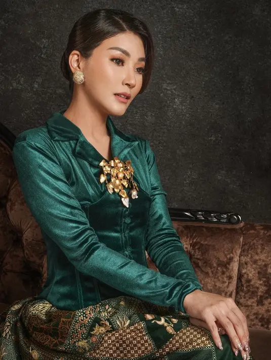 Kebaya model velvet warna hijau emerald dipadukan korset dam bros keemasan besar seperti Sarwendah bisa jadi pilihan busana Natal. Padukan dengan kain batik bernuansa hijau. [@sadwendah29]