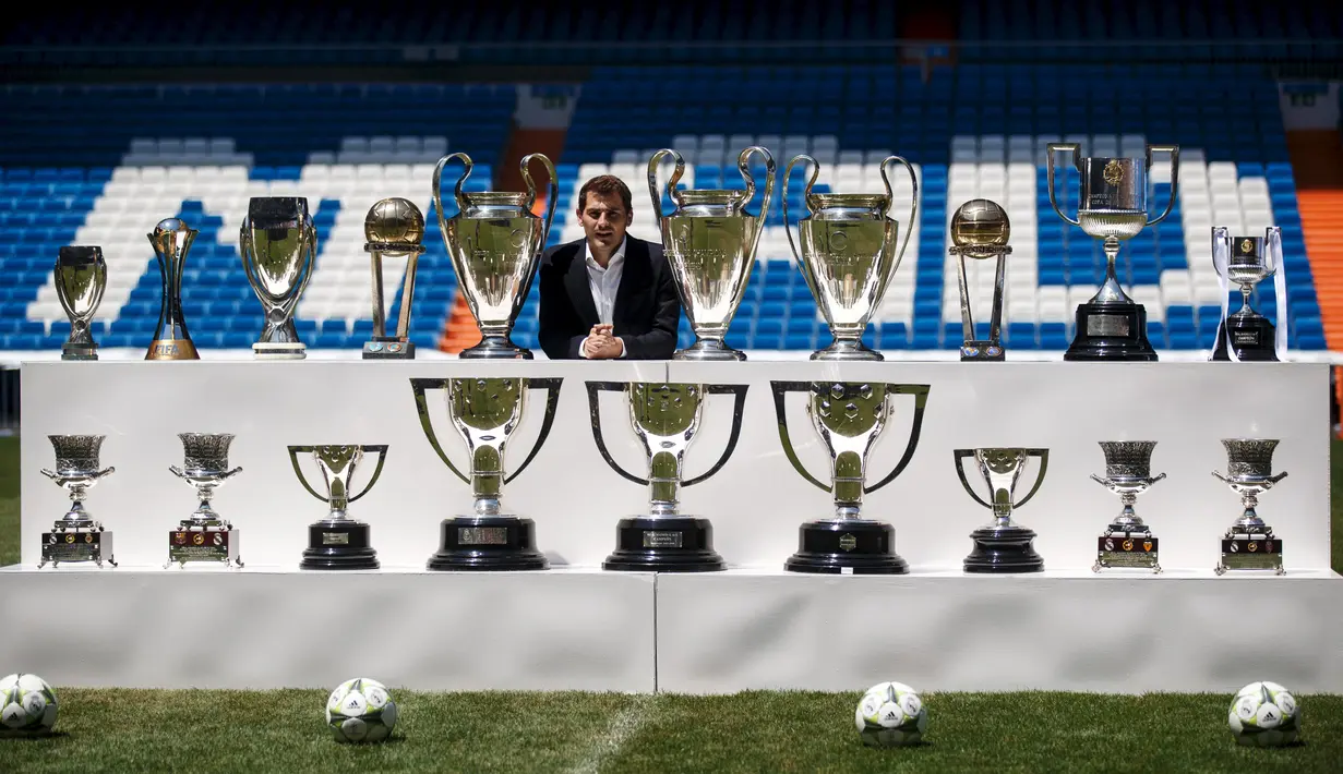 Iker Casillas berpose dengan sejumlah piala yang pernah didapatkan selama menjaga gawang Real Madrid saat upacara perpisahannya di Stadion Santiago Bernabeu, Spanyol, Senin (13/7/2015). (REUTERS/Andrea Comas)