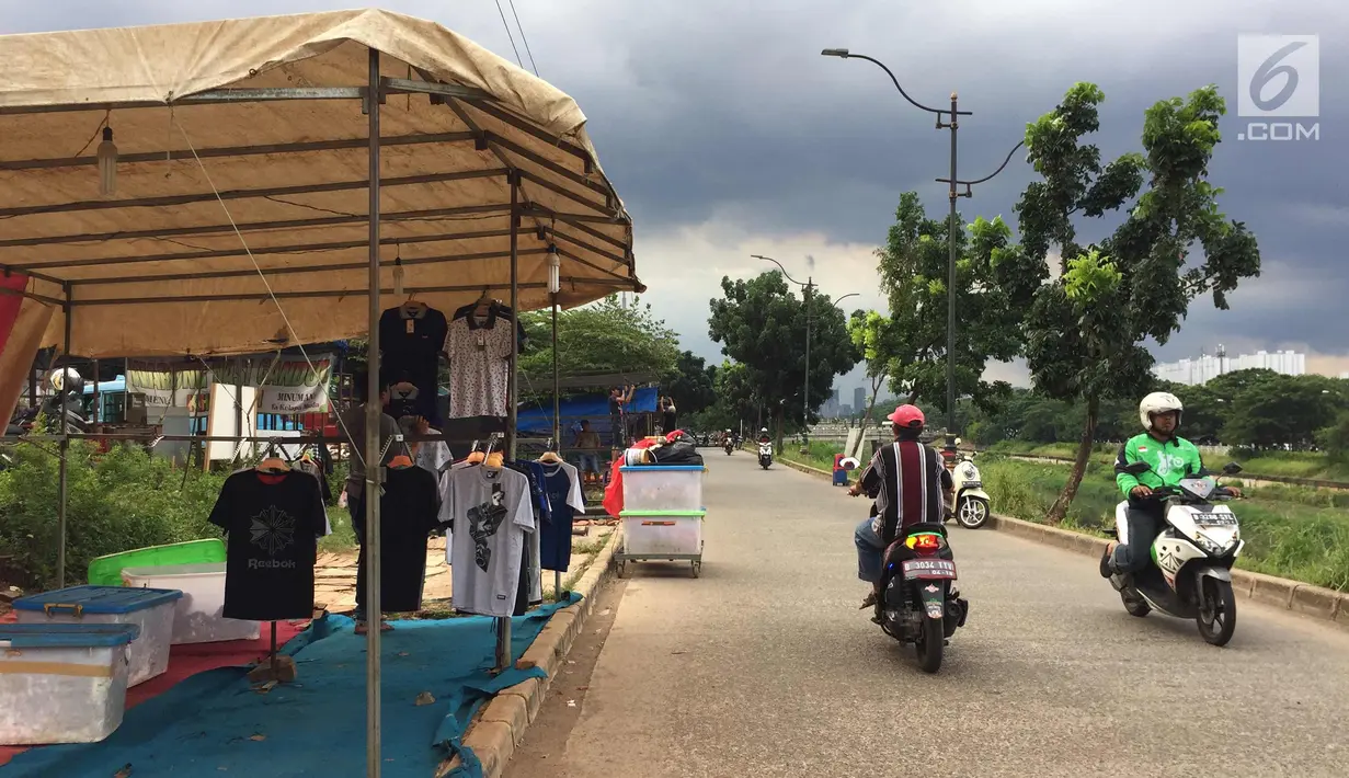 PKL merapihkan dagangannya di Jalur Inspeksi Kanal Banjir Timur, Jakarta, Rabu (3/1). Kurangnya pengawasan menyebabkan jalur inspeksi tersebut dipenuhi PKL sehingga mengganggu ketertiban umum. (Liputan6.com/Immanuel Antonius)